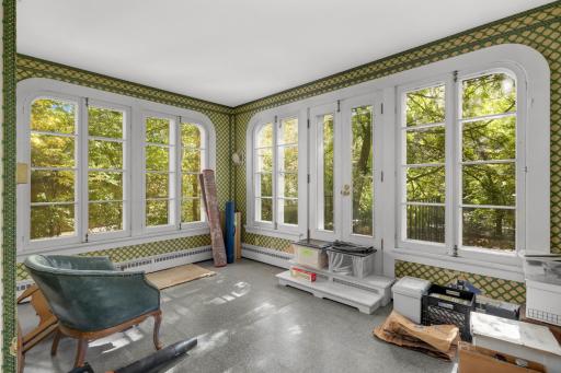 The sunroom features beautiful historic windows and french doors that step out into the side yard