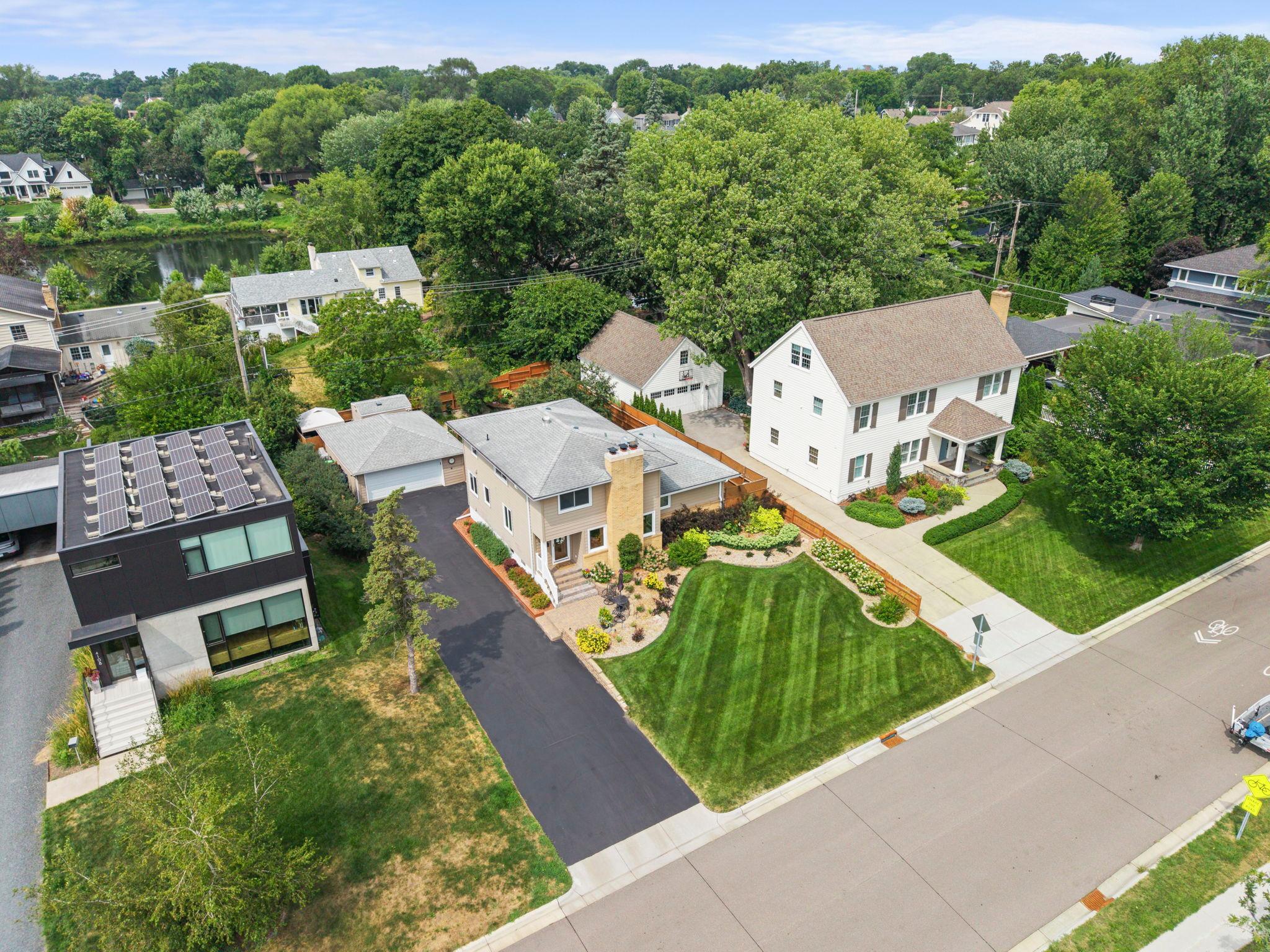 Aerial view captures the home's classic lines, wide driveway, and expansive, well-maintained front yard in the heart of Morningside.