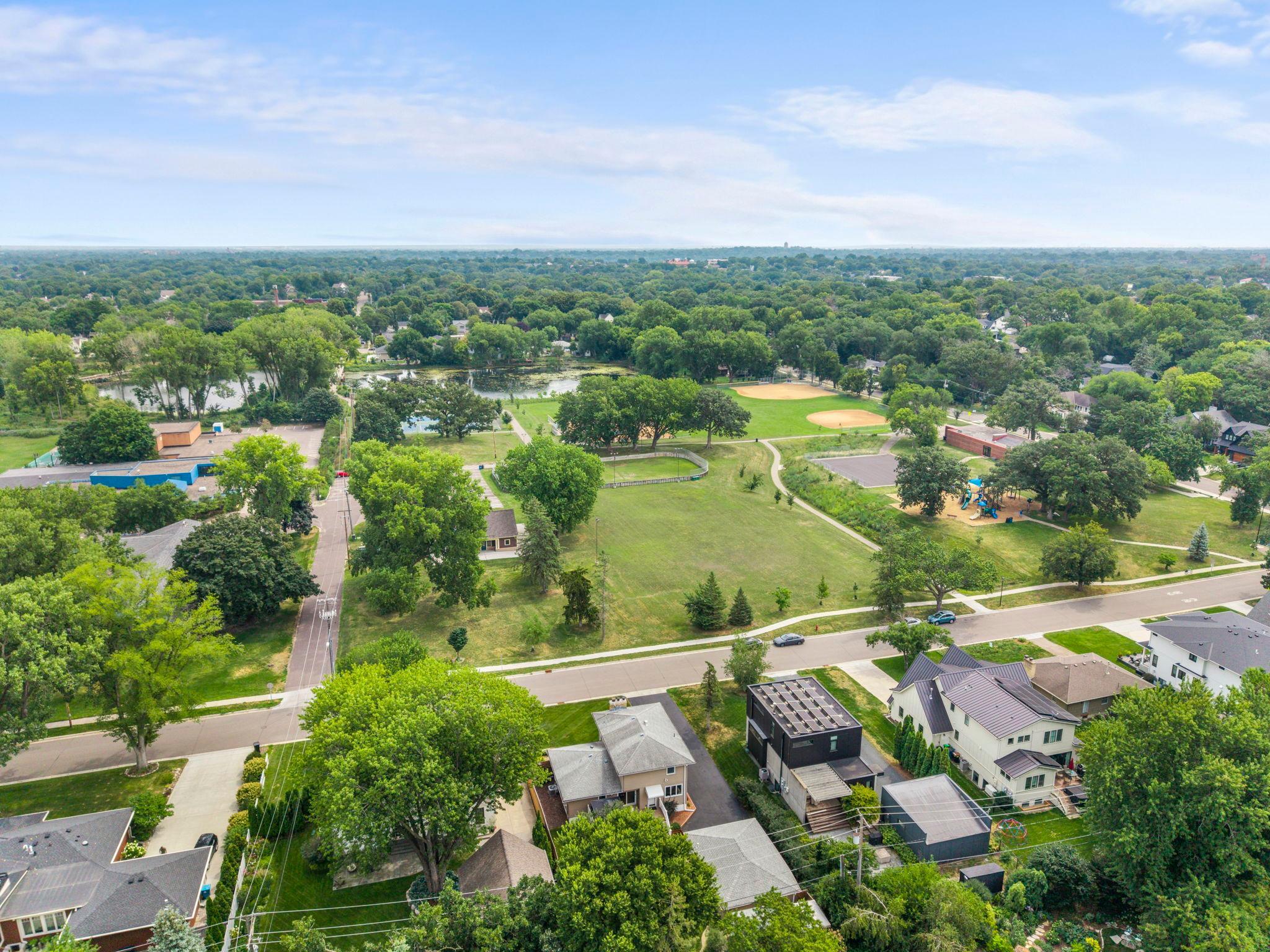 This sweeping aerial view shows Weber Park's pond, ball field, and playground, all within view of this Morningside home.