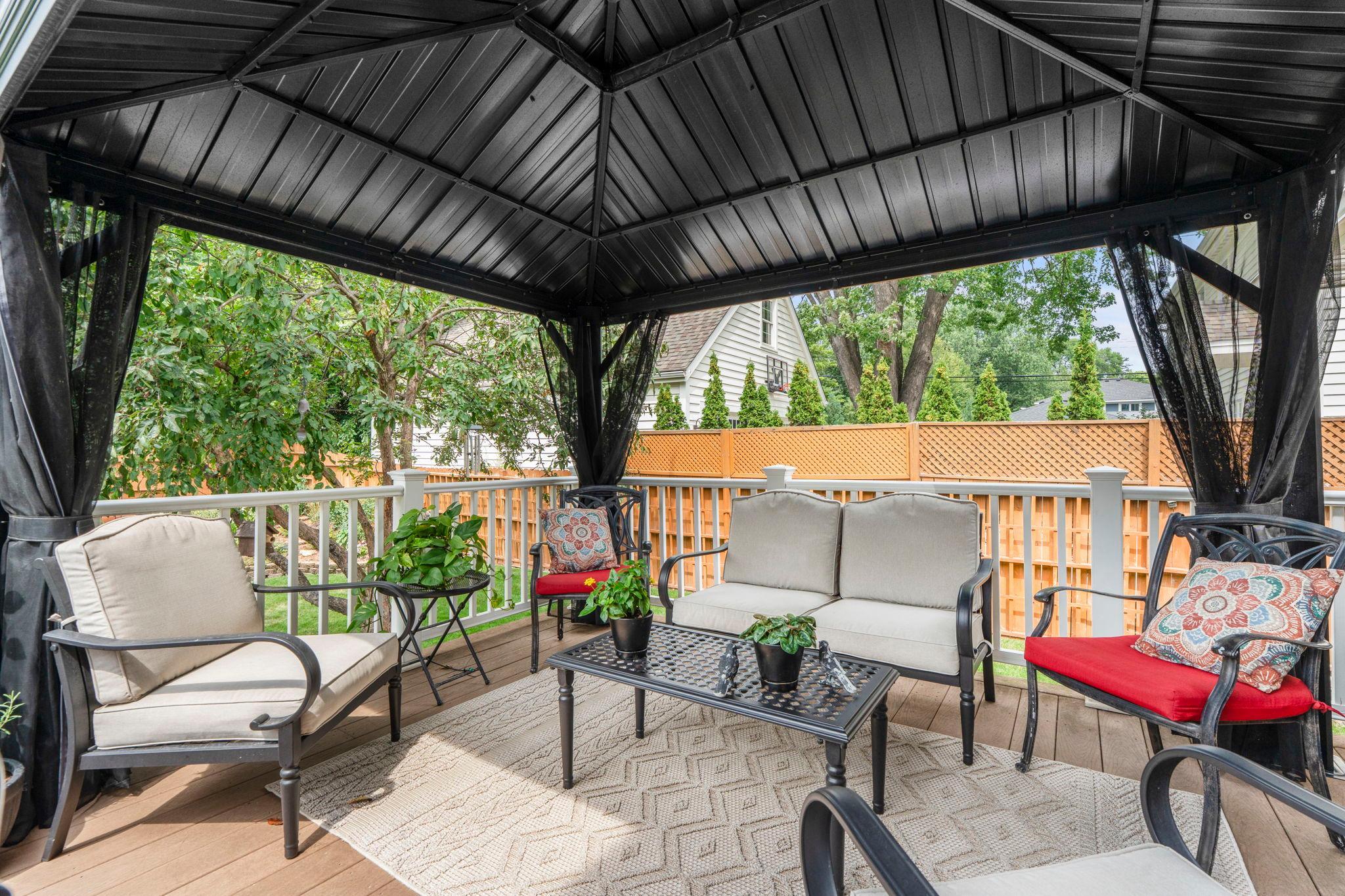 Cozy lounge seating under the gazebo creates an additional outdoor living space on the deck.