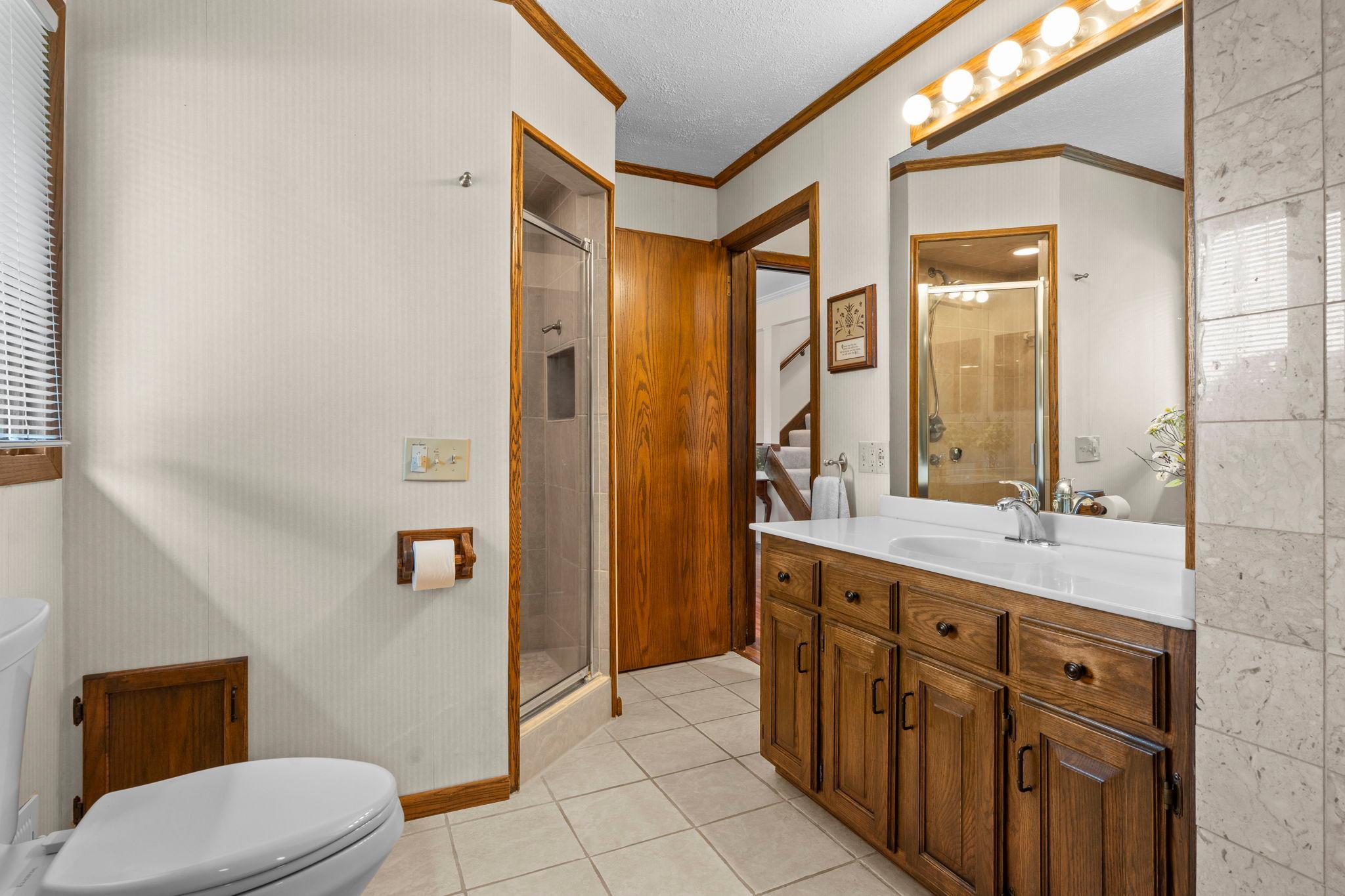 A well-appointed full bath features a long vanity and a step-in glass shower.