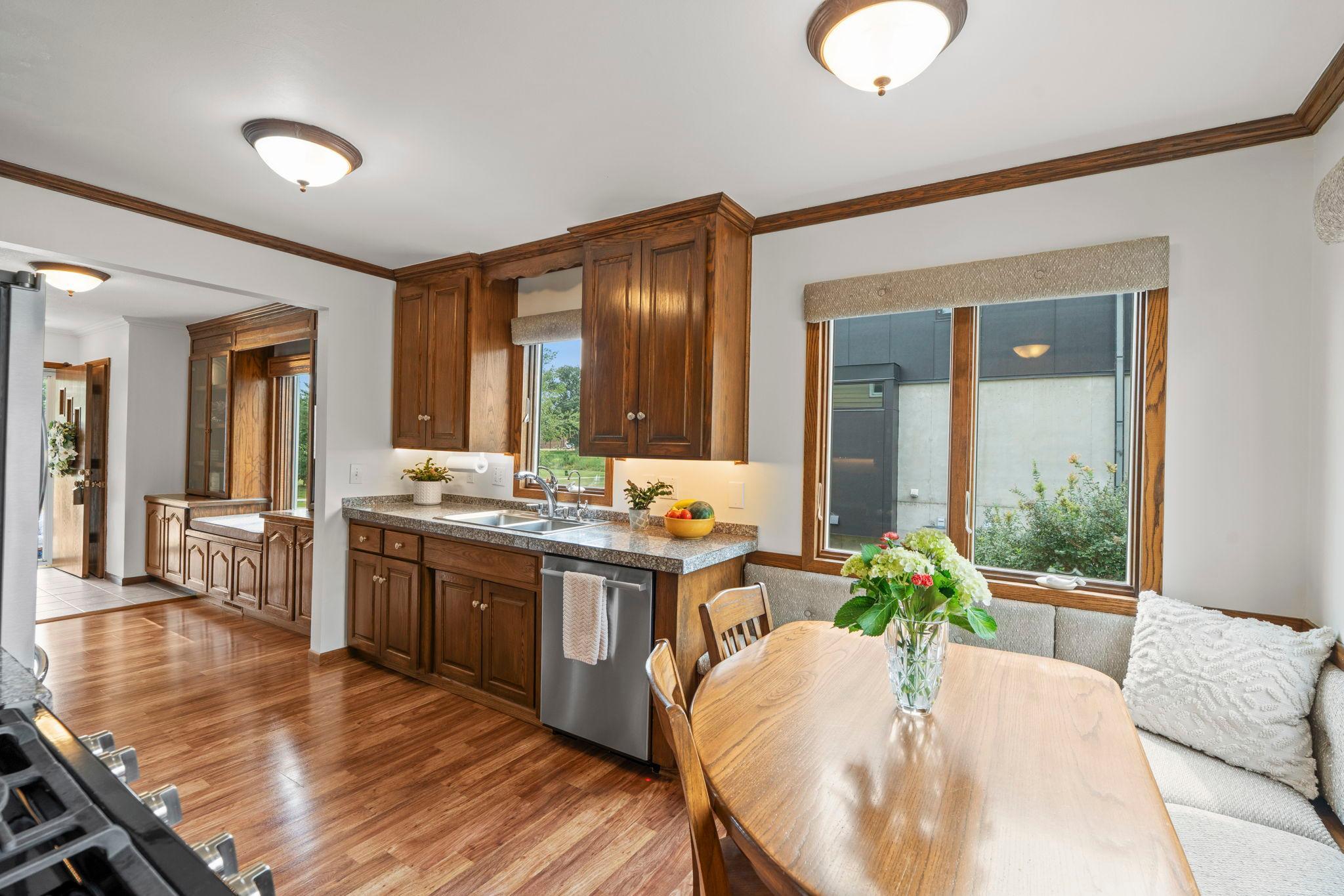 The kitchen's rich wood cabinetry and granite counters pair with a built-in breakfast nook bathed in natural light.