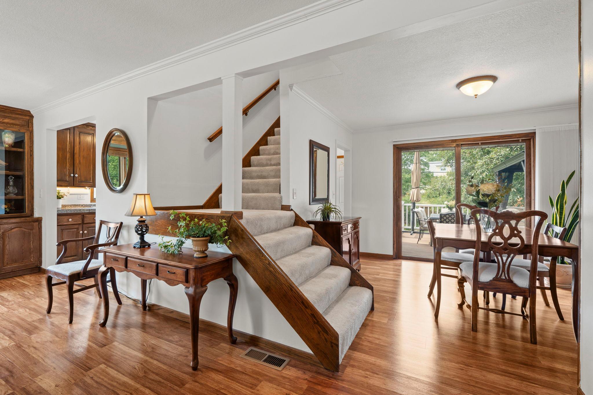 The staircase to the upper level sits just steps from the dining area, with sliding doors leading out to the deck.