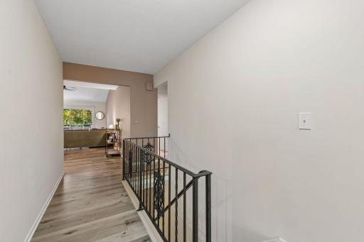 Upper-level hallway connects to the main living area, with a decorative iron stair railing.