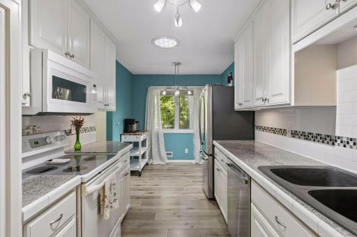 Bright kitchen with white cabinetry, ample counter space and a tile backsplash.