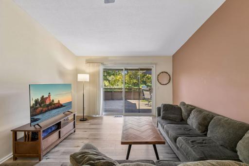 Bright living room with vaulted ceilings and direct access to the spacious deck.