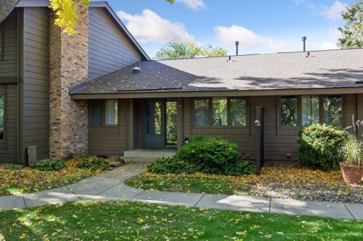 Welcome to 52 Birnamwood Drive! A landscaped walkway leads to the covered front entry of this inviting townhome in a mature, wooded setting.
