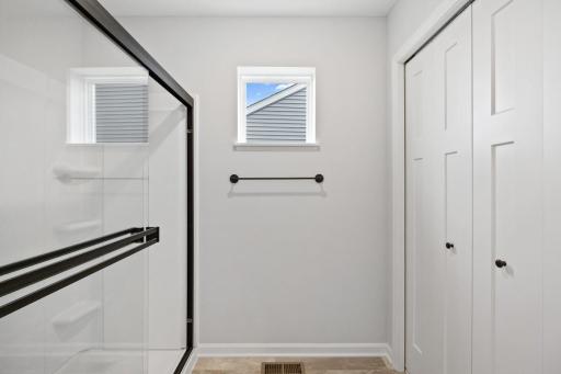 Owner's bathroom shower and large linen closet. (Photo of a similar home - Colors and selections will vary)