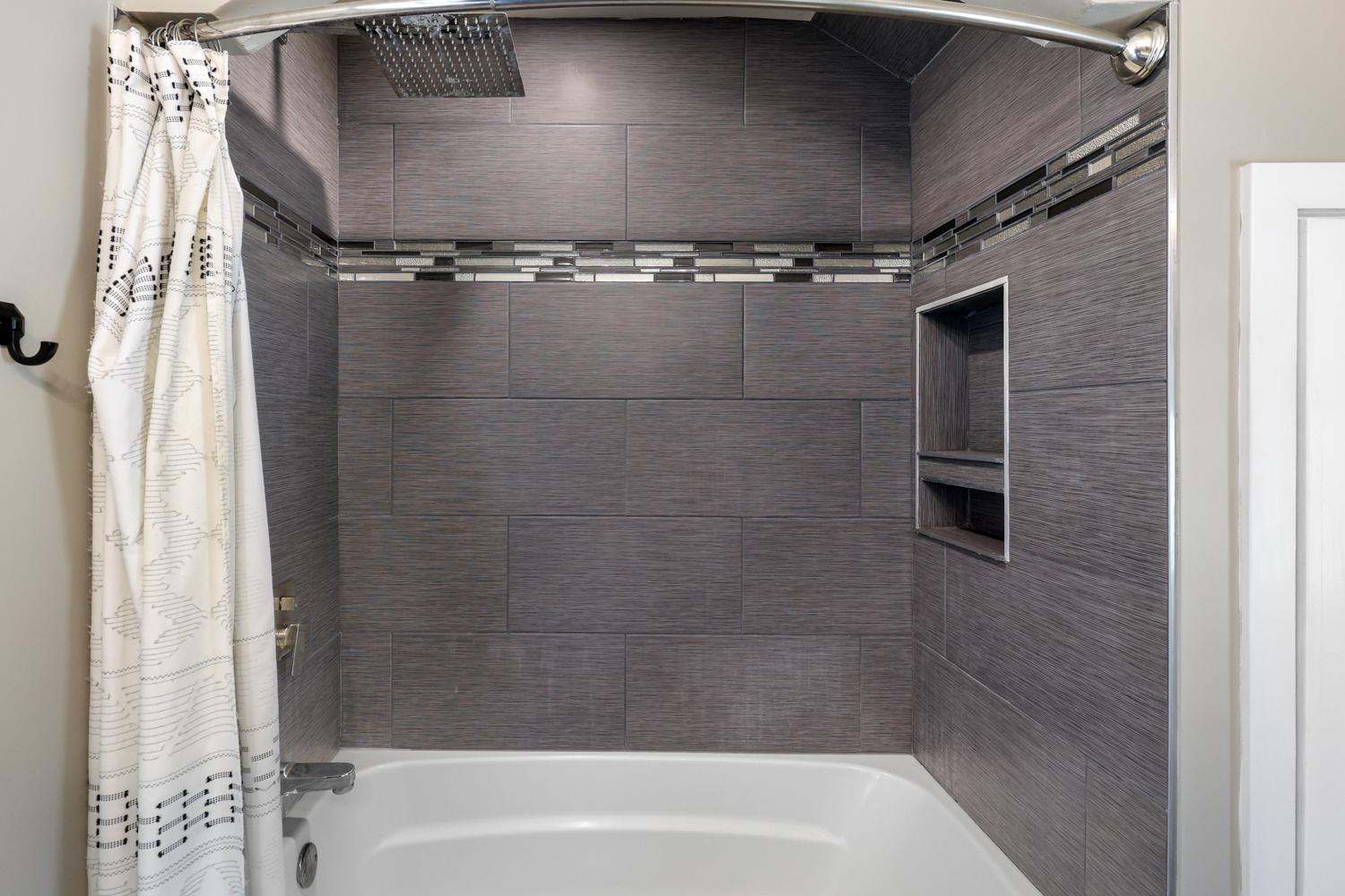 Beautiful custom tile accents this fully remodeled bathroom.