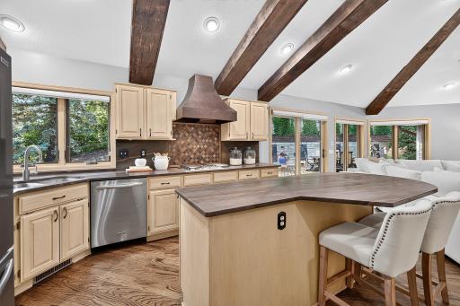 Center island kitchen features stainless steel appliances, eye catching countertops with views capturing the backyard.