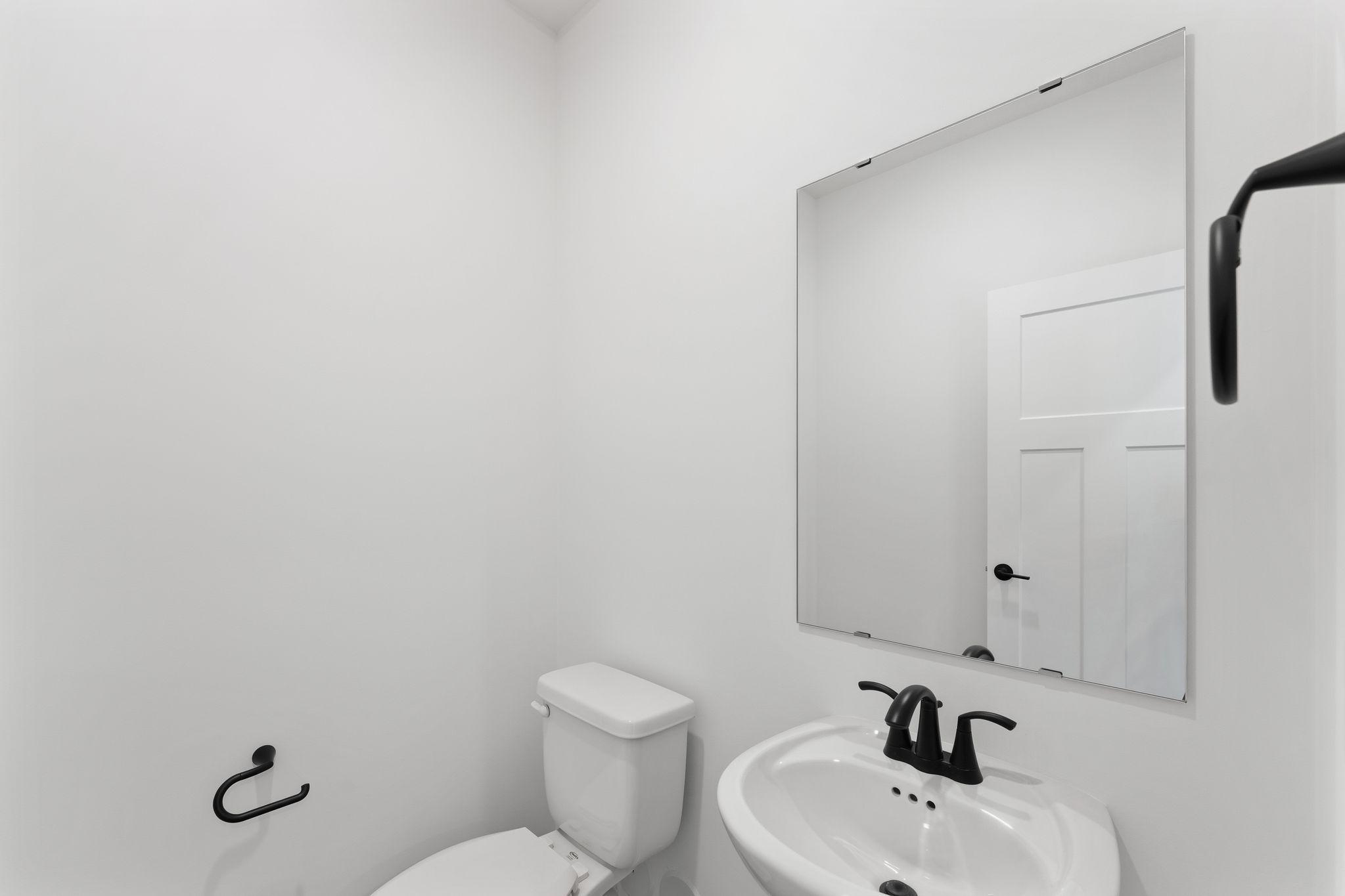 The powder room can be found near the mudroom, offering convenient and private access to both guests and residents.