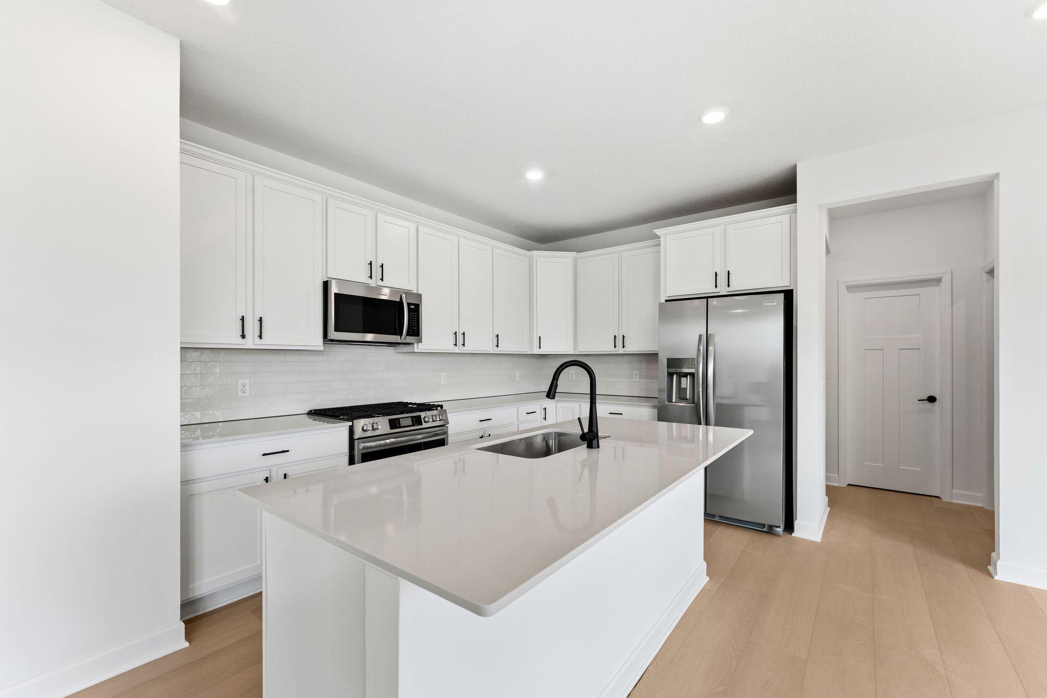 The kitchen features an open and inviting layout with sleek Shaker-style cabinetry, all new stainless-steel appliances and a spacious center island.