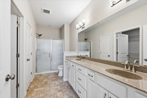Large private bath featuring double sinks and walk in shower!