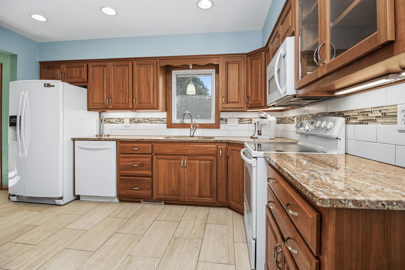 Cherry cabinets, granite countertops, tile backsplash and LVT flooring. Moveable island too.