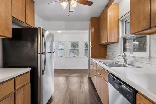 Galley kitchen joins the eating area surrounded with windows over looking the backyard.