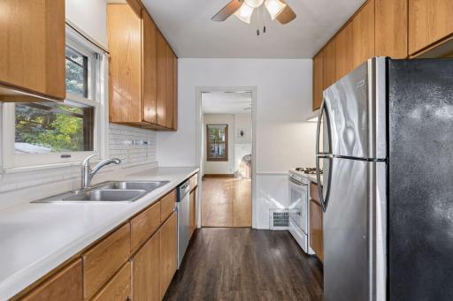 Galley kitchen joins the eating area surrounded with windows over looking the backyard.