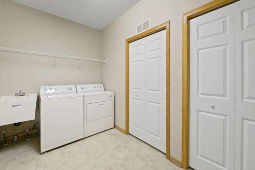 The laundry room has a huge storage closet, room for plenty of shoes and a laundry tub.