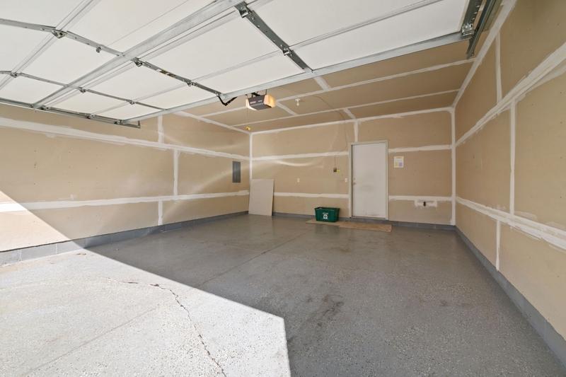 The two-car garage has a painted floor, is drywalled, and has lots of storage room.