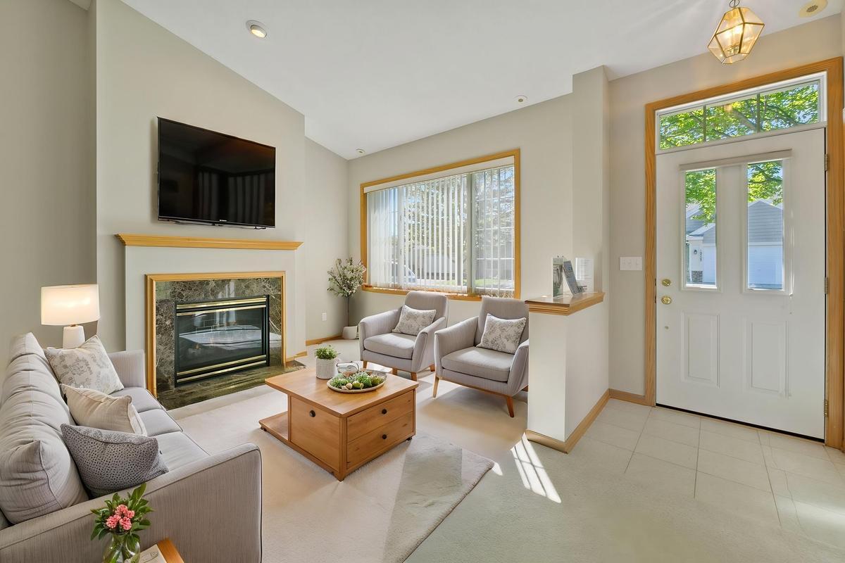 The living room features a fireplace and vaulted ceilings. (Photo virtually staged)