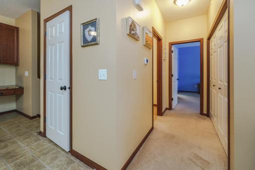 Down this hall lies the laundry, a den, and the primary bedroom suite.