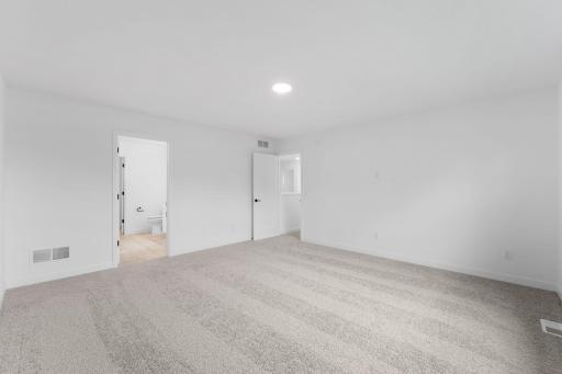 This spacious bedroom is complete with ample room for a king-sized bed