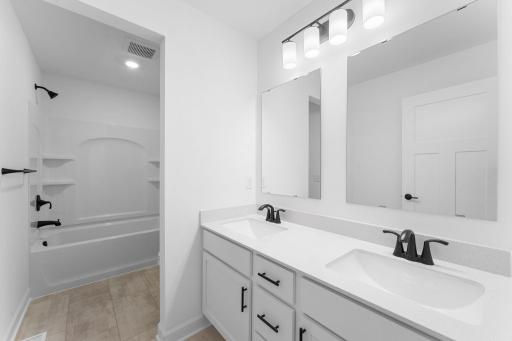 This full bathroom is conveniently located on the second floor and showcases dual sinks and a shower-tub combination.