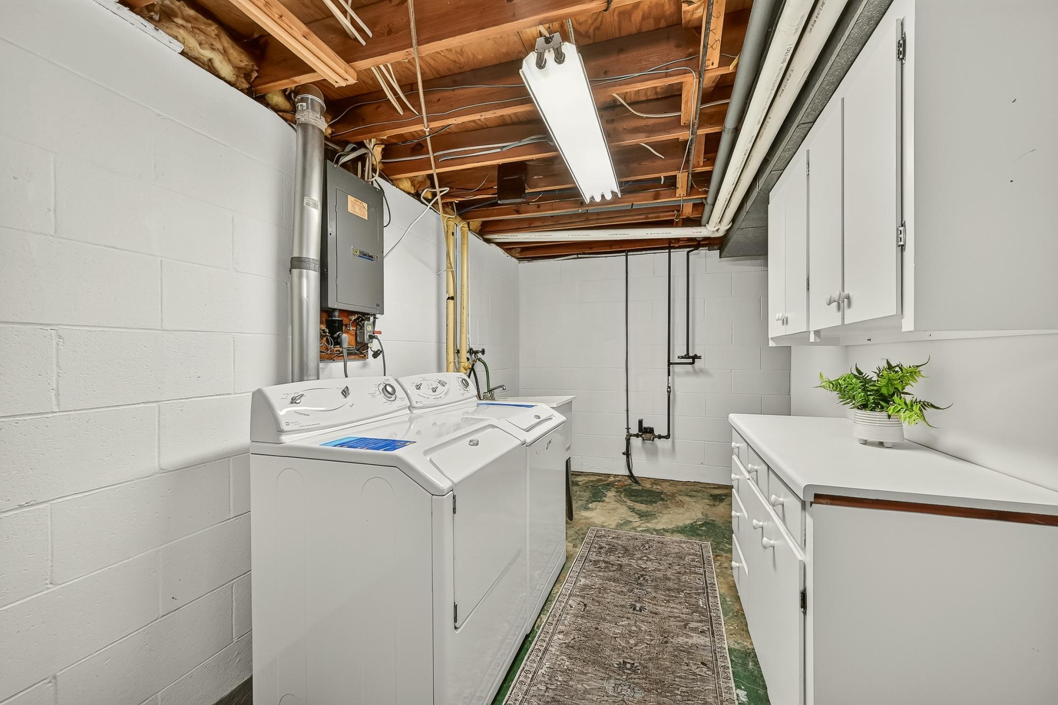 Lower level laundry room with utility sink and nice built in storage,