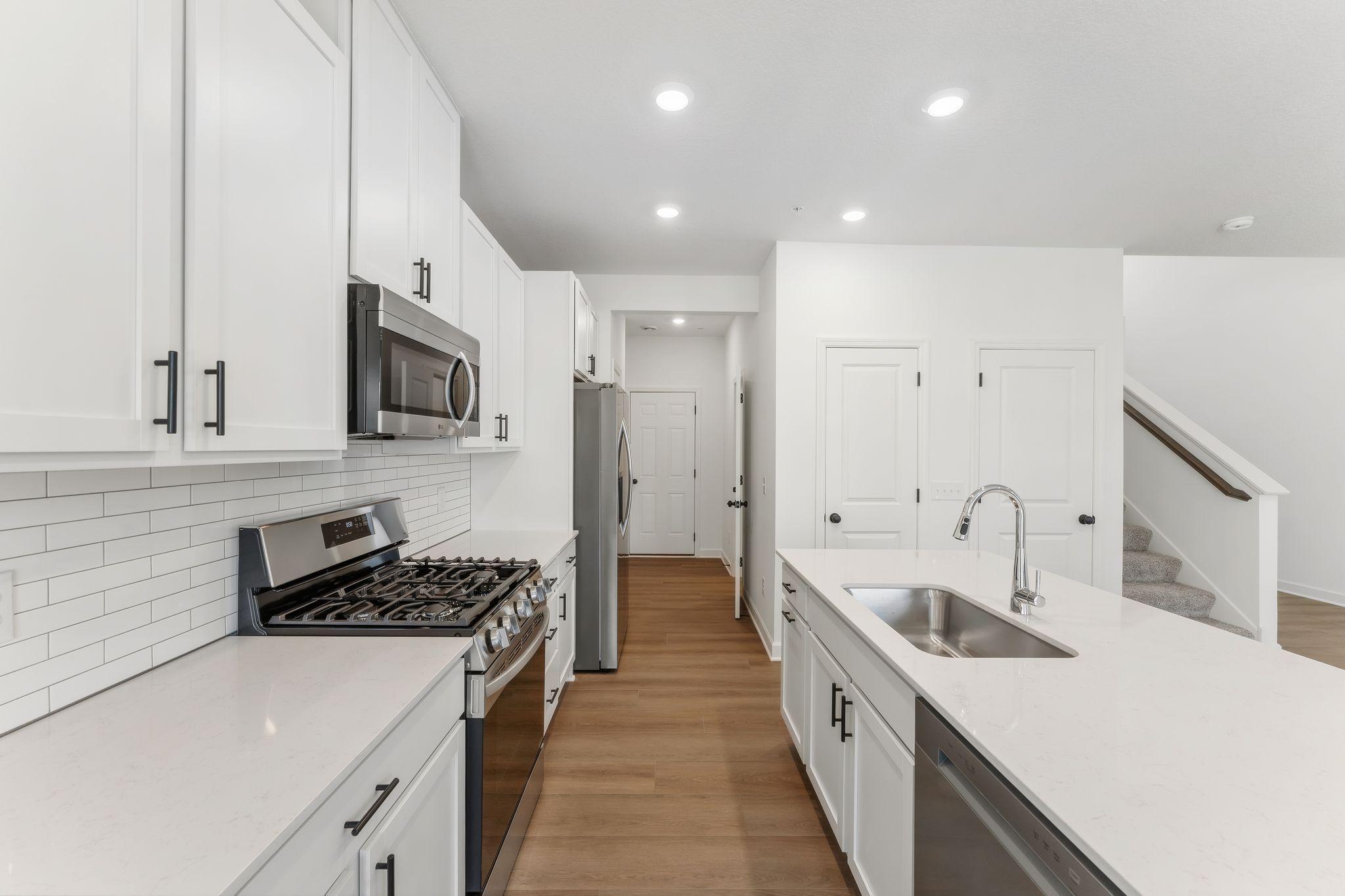 A subway tile backsplash atop the 5-burner gas cooktop with an overhead microwave meets style with functionality