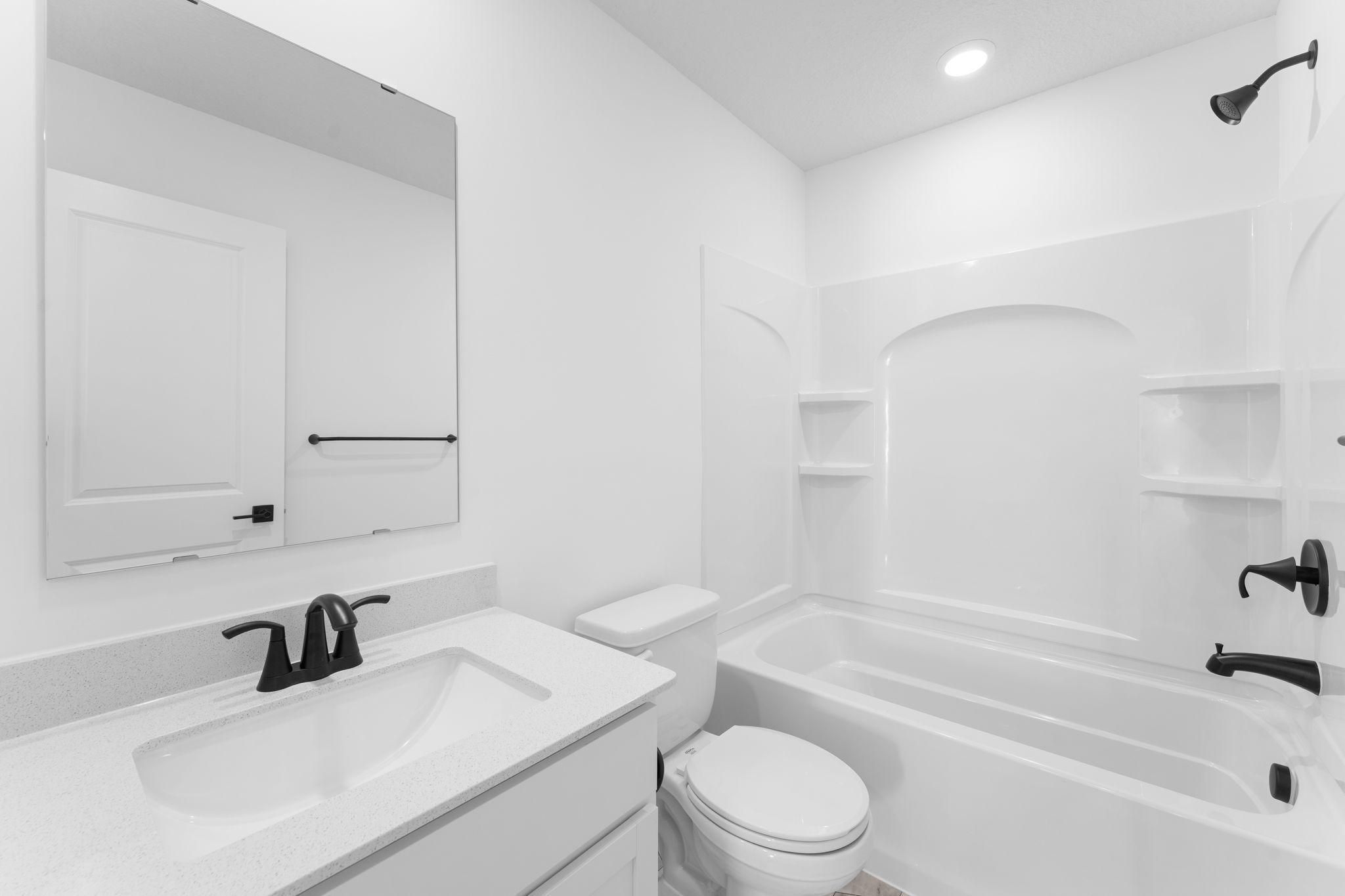 (Photo of a similar home, actual finishes may vary) This full-sized bathroom includes a stylish vanity and a versatile shower-tub combo