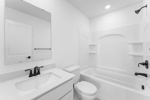 (Photo of a similar home, actual finishes may vary) This full-sized bathroom includes a stylish vanity and a versatile shower-tub combo