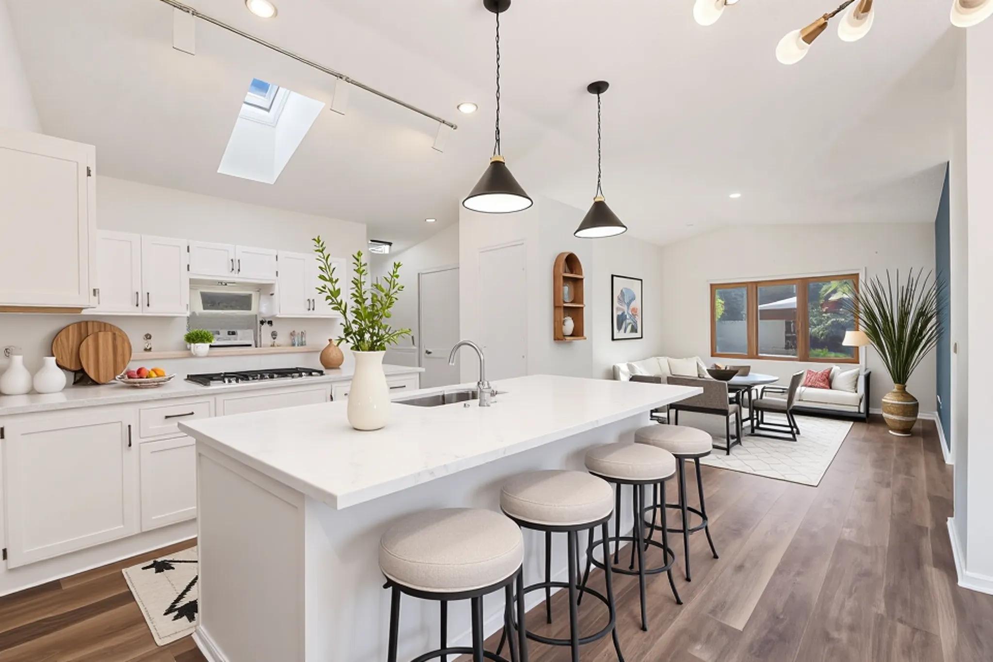 Virtually staged kitchen with breakfast bar. Opens to living room and dining room.