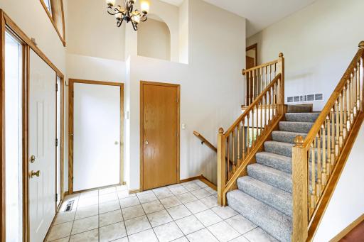Step into this bright, open, and inviting foyer featuring soaring ceilings, a charming architectural niche, fresh paint, new carpeting, and beautiful oak railings. A warm and welcoming first impression!