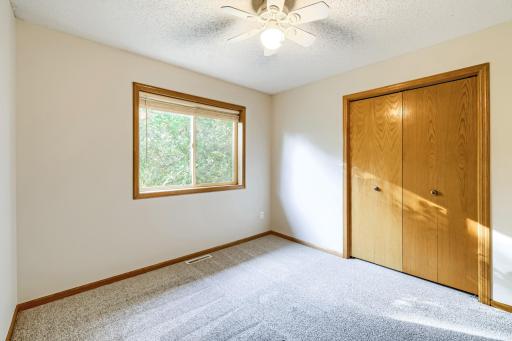 Bright and cheerful third upper-level bedroom features fresh neutral paint, new carpeting, a spacious double closet, and a large window offering beautiful views. Perfect for a bedroom, guest room, or home office!