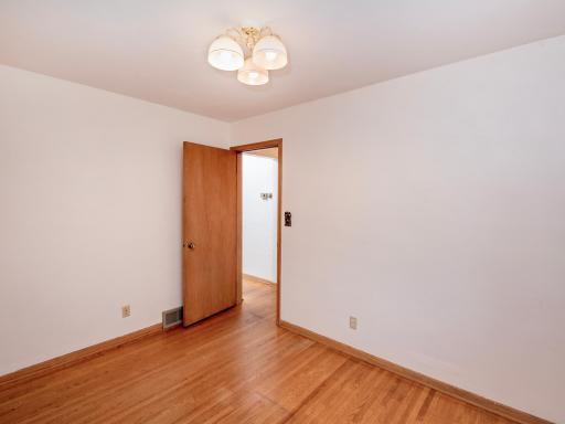 Bedroom #3 with a doorway that leads down the hallway to the bathroom and 2 other bedrooms.