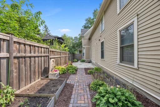 A paved path from the patio leads to a charming garden area.