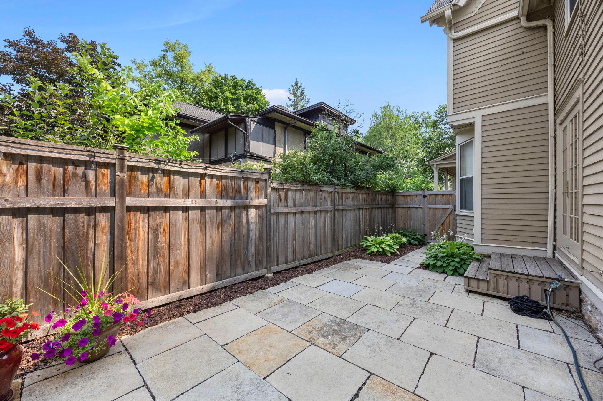 A paver patio sits just outside the convenient side-door access from the kitchen, creating an ideal flow for indoor-outdoor entertaining.