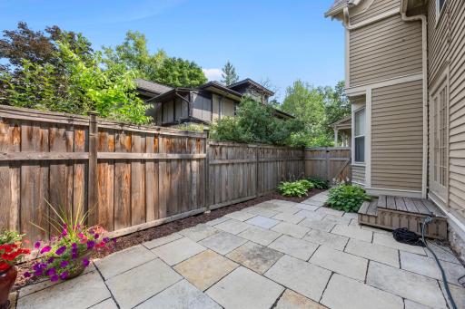 A paver patio sits just outside the convenient side-door access from the kitchen, creating an ideal flow for indoor-outdoor entertaining.
