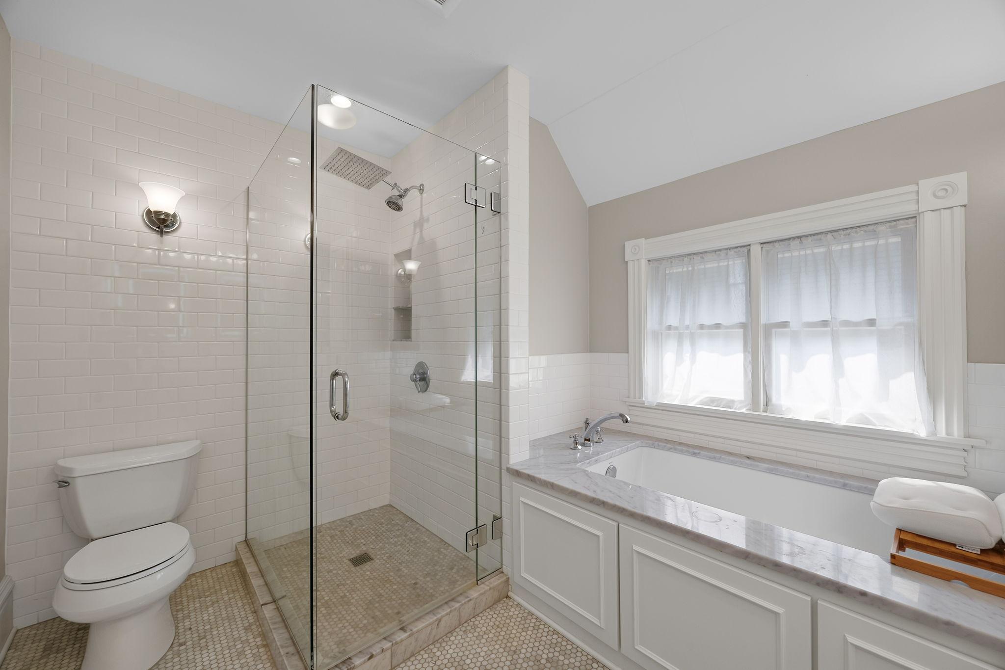 The bathroom features an oversized soaking tub, spacious walk-in shower, dual sinks, and illuminated mirrors.