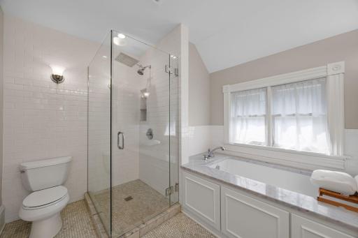 The bathroom features an oversized soaking tub, spacious walk-in shower, dual sinks, and illuminated mirrors.