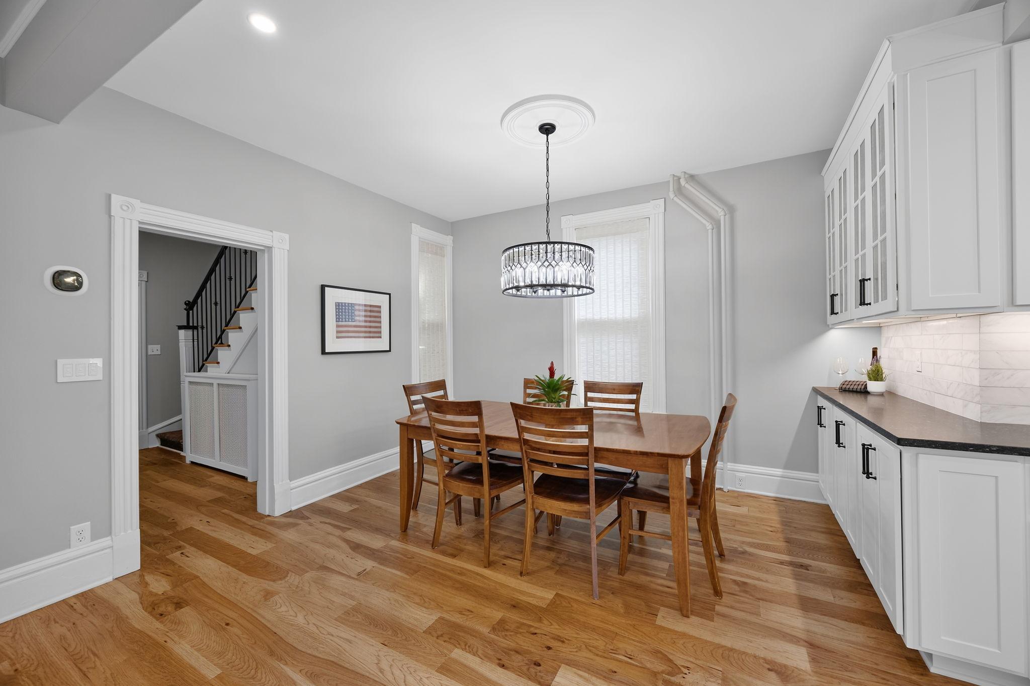 Adjacent to the kitchen, the inviting dining room features a stylish hanging light fixture and offers the perfect setting for everyday meals or hosting guests.