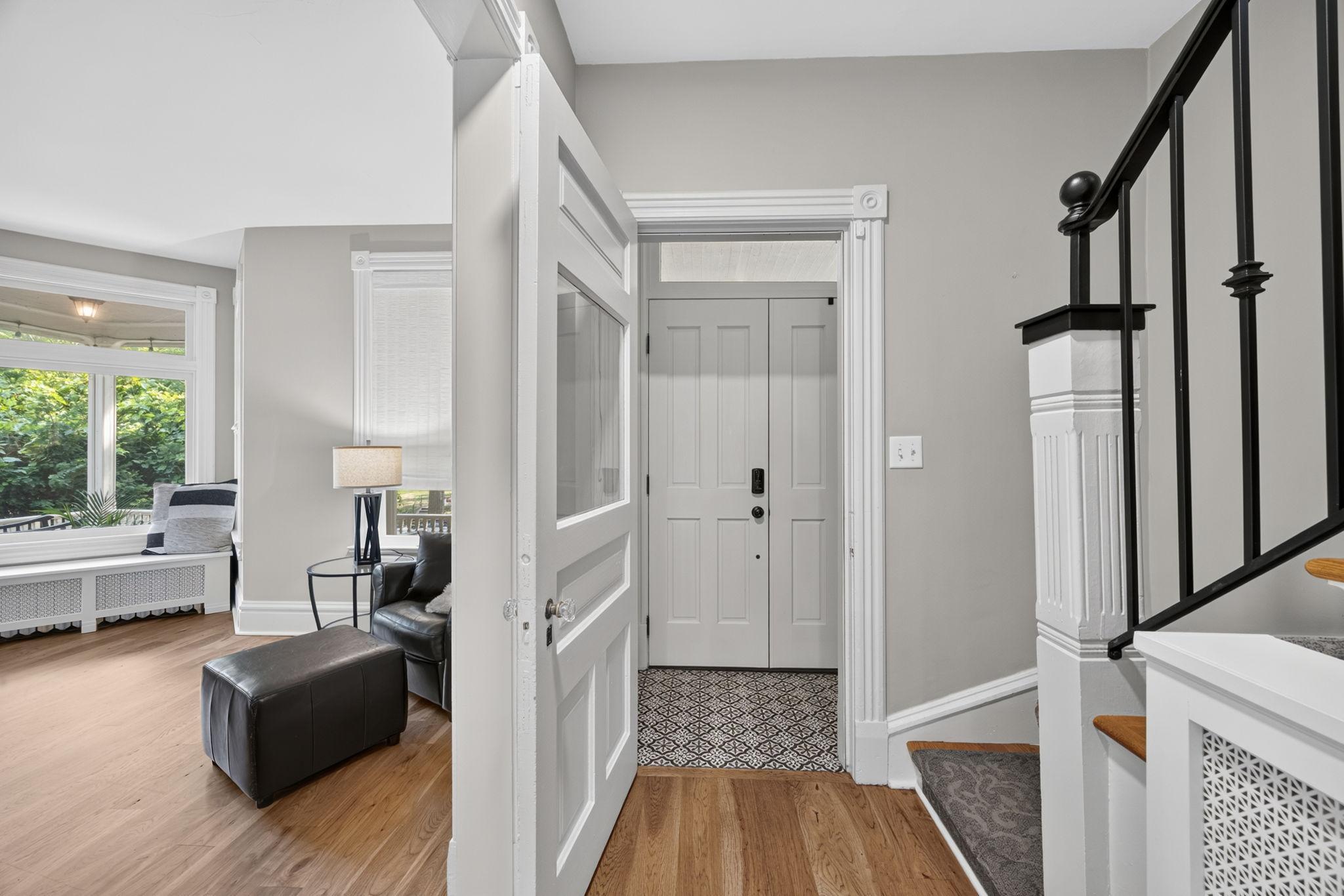 Inside, warm new hardwood floors span the main level, creating a welcoming, cohesive feel. A newly tiled entry, new wood front door, & new iron railing on the front stairs add a fresh, polished touch while complementing the home’s timeless character.