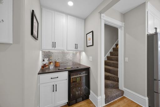 A nearby beverage station offers additional granite countertops, cabinetry, and a beverage refrigerator, while the convenient 7x4 pantry incorporates the original pocket door from the dining room, adding a unique touch of character.