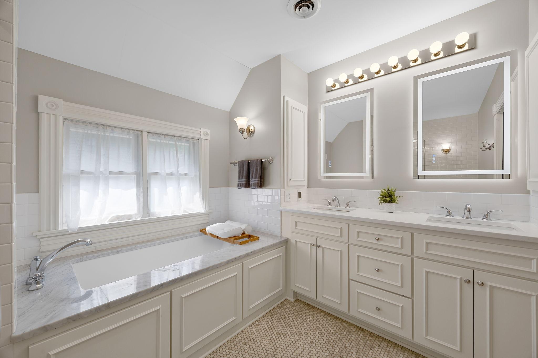 Just outside the primary suite are dual closets and access to a beautifully updated full bathroom with comfortable heated floors through a convenient pocket door.