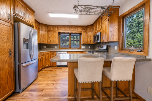 Eat in kitchen has a breakfast bar and all of the stainless steel appliances are less than two years old and go with the home. This is adjacent to the formal dining room. Virtually staged.
