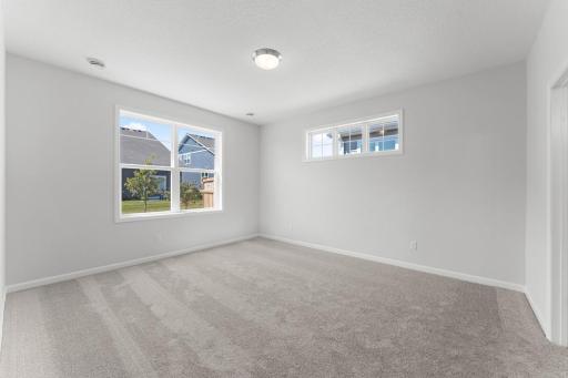 The primary on-suite can accommodate many furniture arrangements. Similar home shown. Color and options can vary.