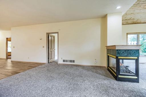 Living room with 3-sided fireplace open to living room/dining room & sunroom