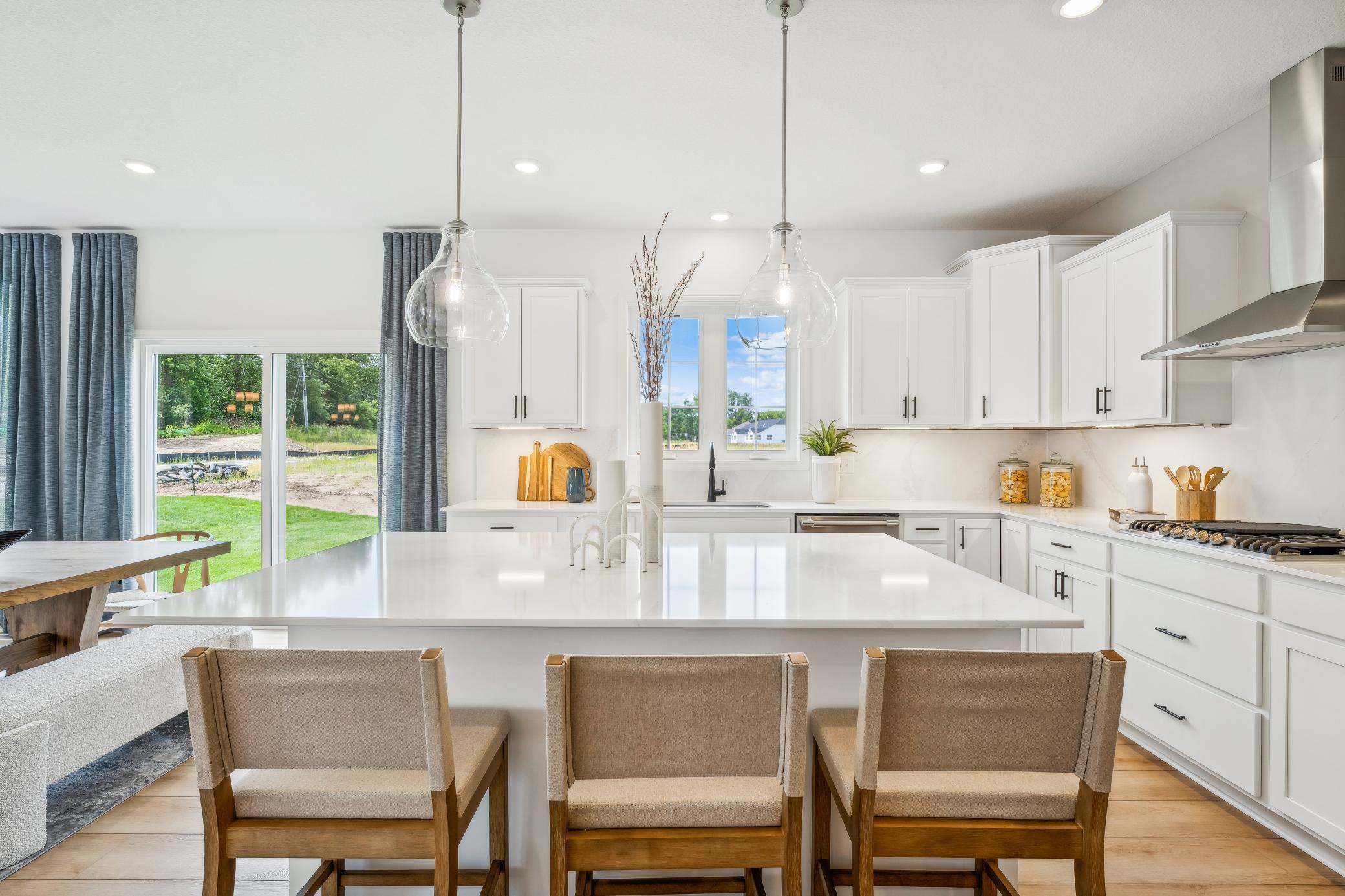 (Photo of model home, finishes will vary) The focal point of this modern kitchen is an inviting center island that provides additional counter and seating space. It is surrounded by ample cabinetry and all-new stainless steel appliances.