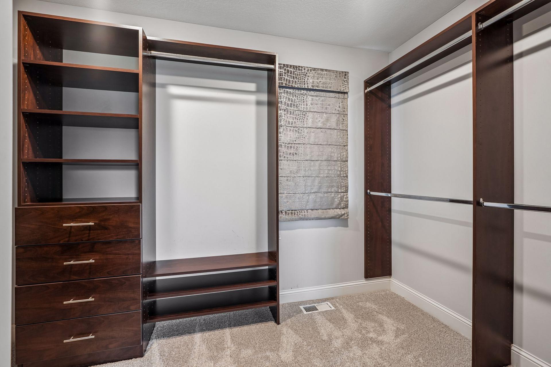 A spacious walk-in closet with custom shelving and organization, complemented by tailored window treatments for a polished finishing touch.