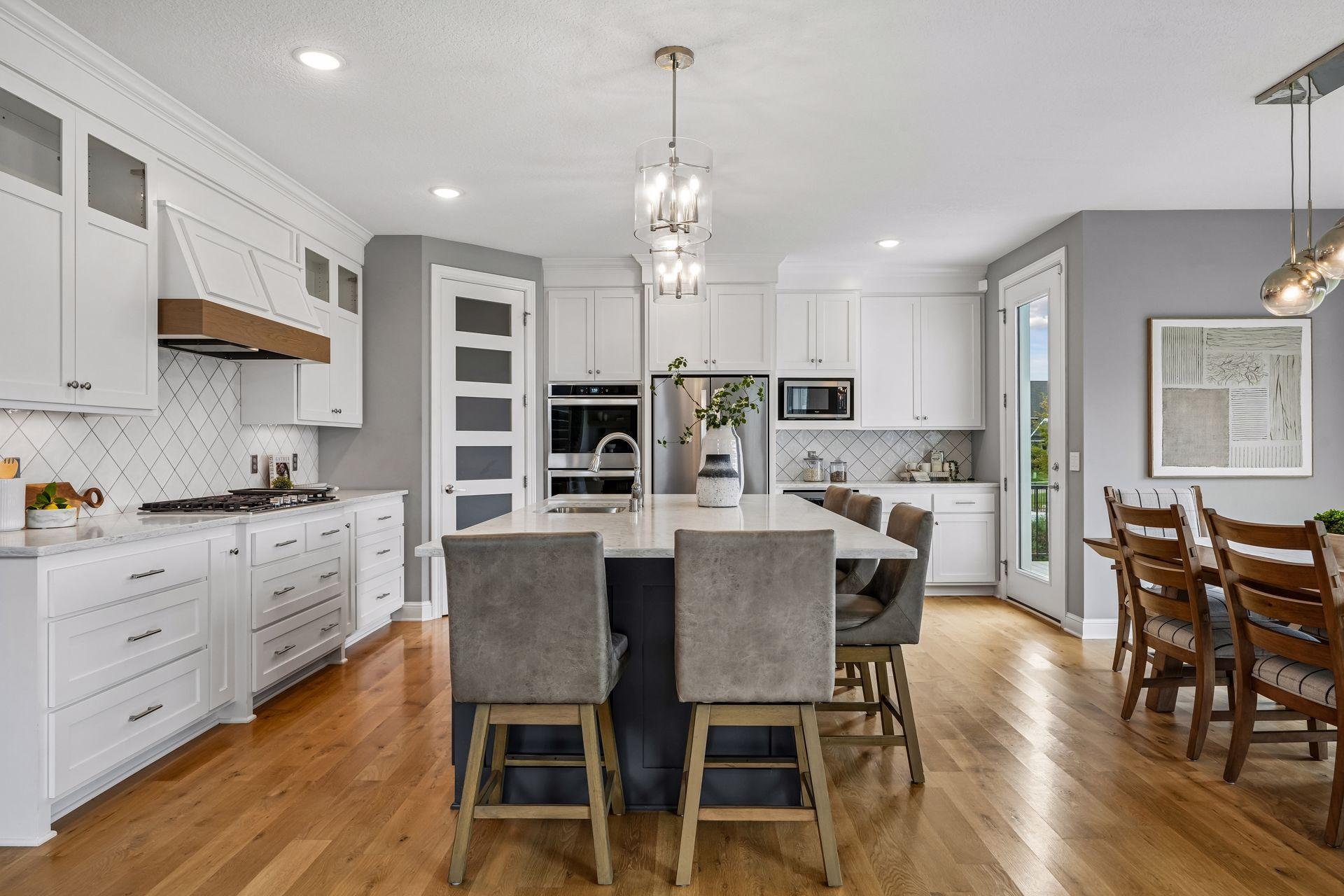 Generous granite island offers ample space for meal prep, casual dining, and gathering.