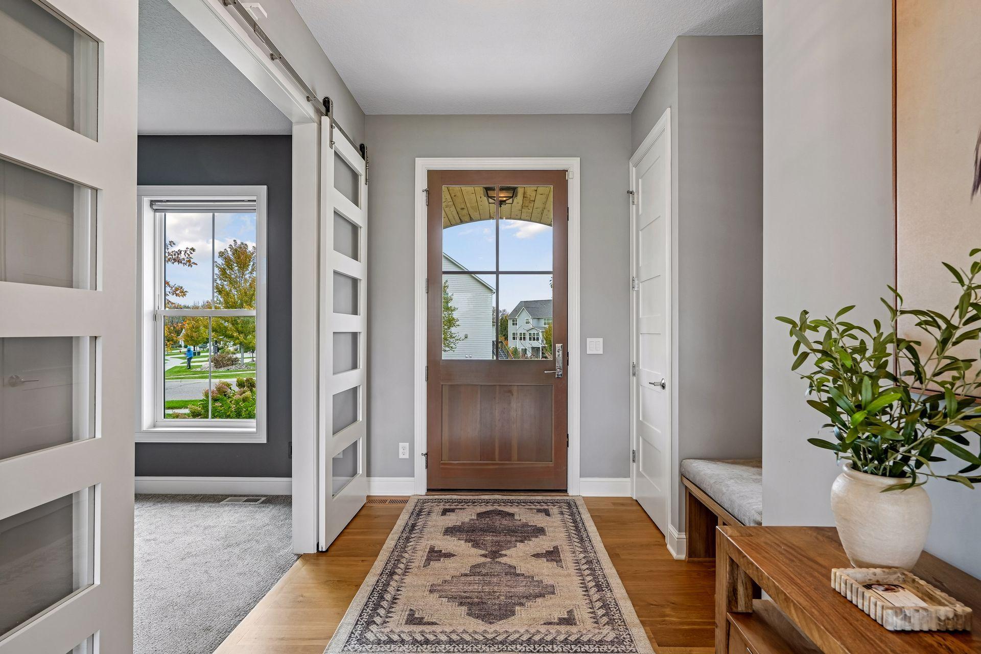 A bright, welcoming entryway featuring a convenient coat closet and built-in bench with custom-fit cushioning.